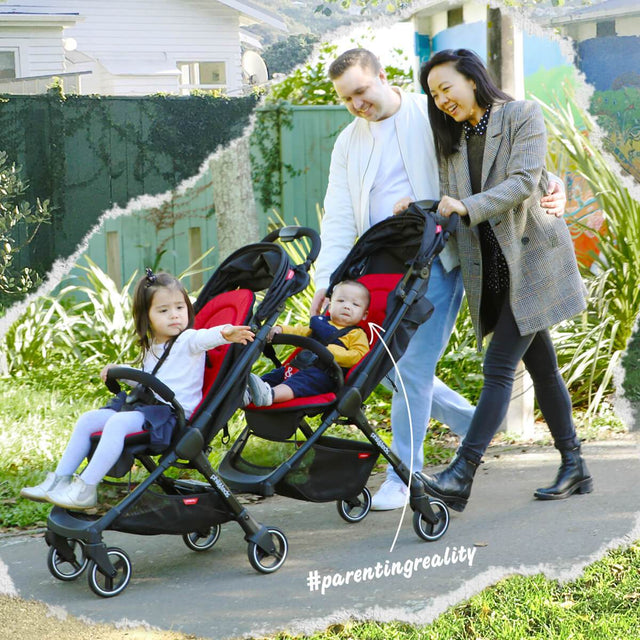happy loving couple out for a walk with the go buggy and go double kit for two kids to enjoy a walk in the park
